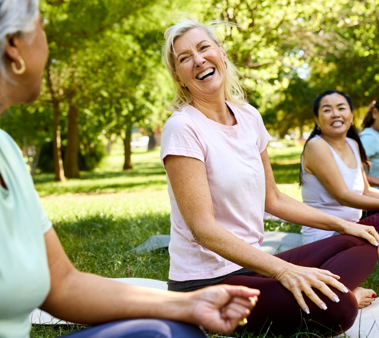 Women laughing together during an outdoor stretching class